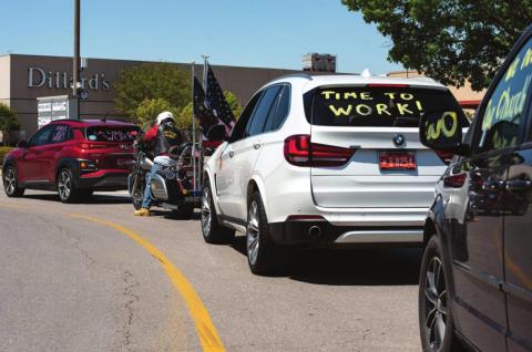 A line of cars waits to exit Penn Square Mall in Oklahoma City April 15 before driving to the State Capitol. The rally, organized by a group called OK Back 2 Work, was intended to push state leaders to lift business closures enacted because of the pandemic. Whitney Bryen | Oklahoma Watch